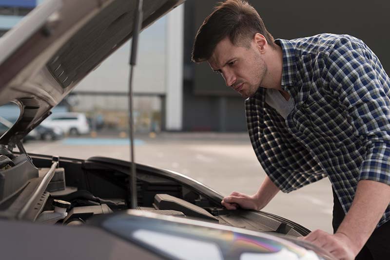a man checking his vehicle before traveling